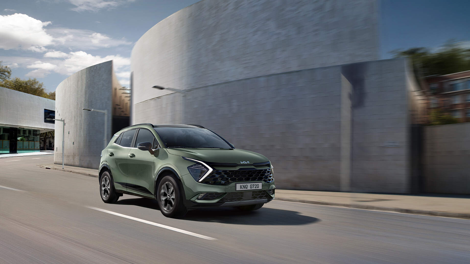 Front side of Sportage driving on a road with high walls